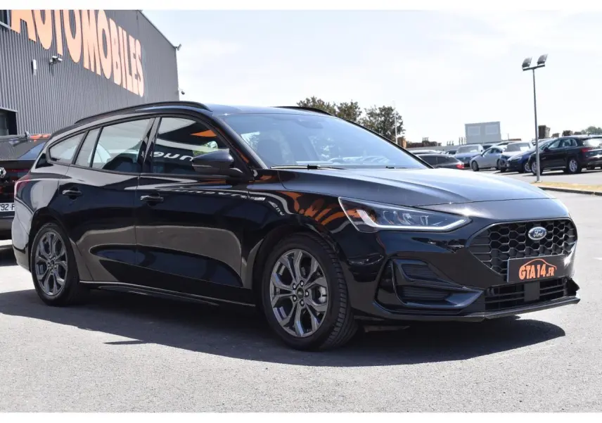 Ford Focus SW 1.5 EcoBlue 115 Powershift ST LINE X noir Agate, vue 3/4 avant droit, calandre hexagonale distinctive.