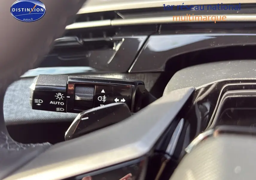 Gros plan sur la commande des phares automatiques à gauche du volant du Peugeot 3008 gris titane 2025.