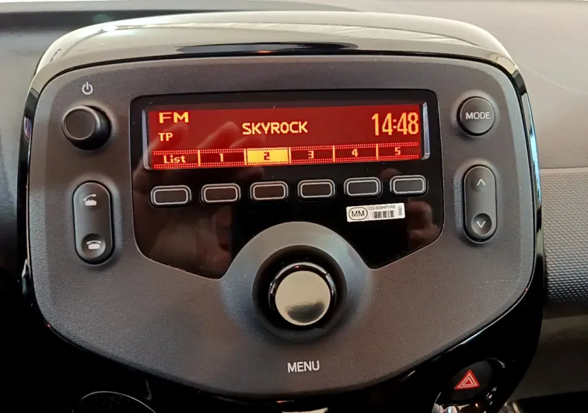 Gros plan sur l’autoradio noir de la Citroën C1 blanc, affichant la radio FM Skyrock à 14h48.