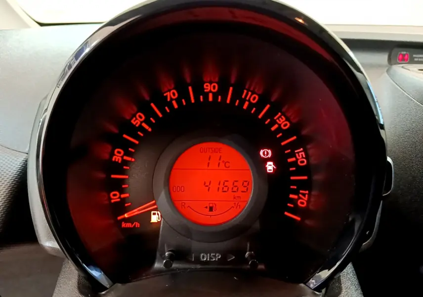 Vue rapprochée du compteur de vitesse rouge de la Citroën C1 blanche, affichant 41669 km et 11°C extérieur.