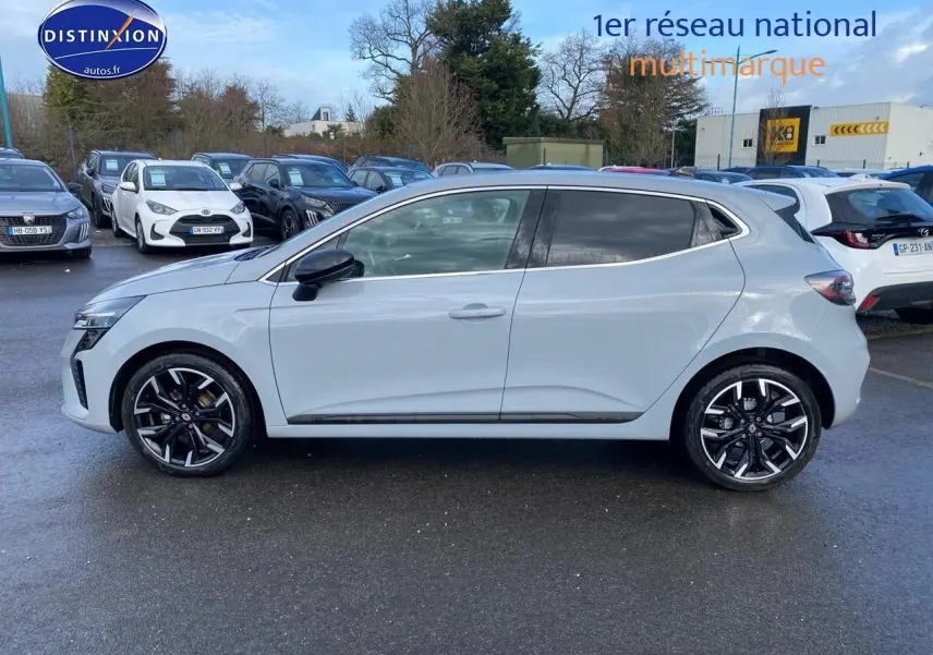 Renault Clio V gris rafale vue de profil côté gauche sur parking avec jantes alliage noires et chromées.