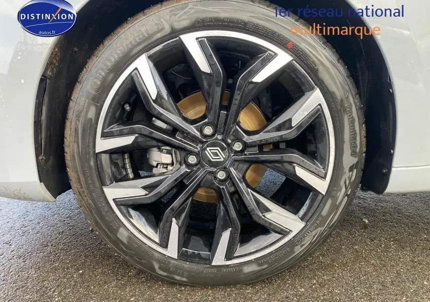 Gros plan sur la roue avant droite avec jante alliage noire et argentée d'une Renault Clio V gris rafale.