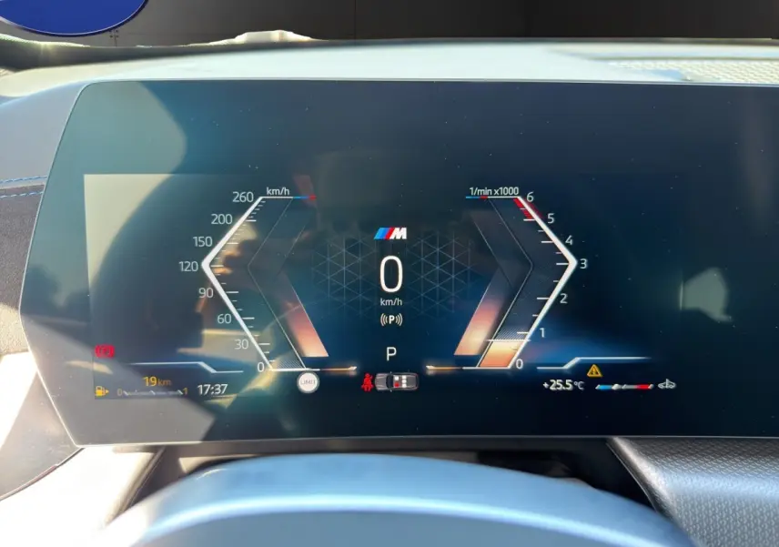 Vue rapprochée du tableau de bord numérique de la BMW X1 sDrive20d blanc, affichant la vitesse et le régime moteur.