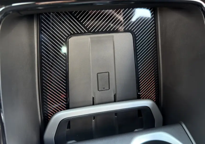 Gros plan sur le chargeur sans fil au centre de la console d'une BMW X1 blanche, finition M SPORT.