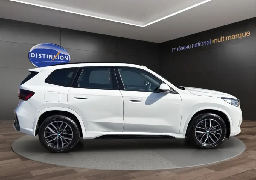 BMW X1 sDrive20d blanc vue de profil côté gauche avec jantes alliage et toit noir contrasté