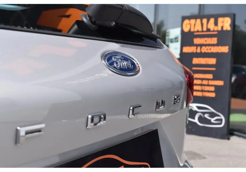 Gros plan sur l'arrière droit d'une Ford Focus SW Moondust Silver avec logo et sigle visibles.