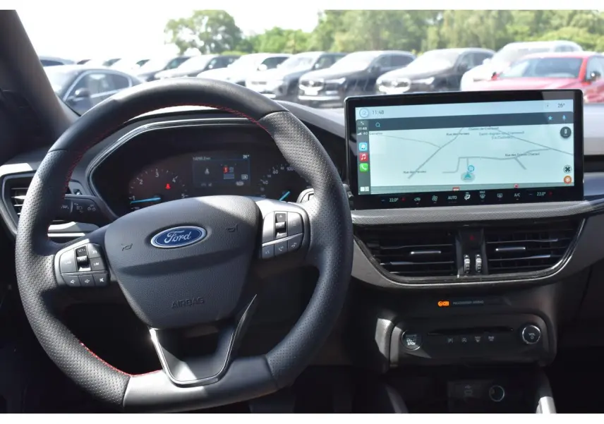 Vue intérieure centrée sur le volant Ford et l’écran tactile de navigation du Ford Focus SW Moondust Silver 2025.