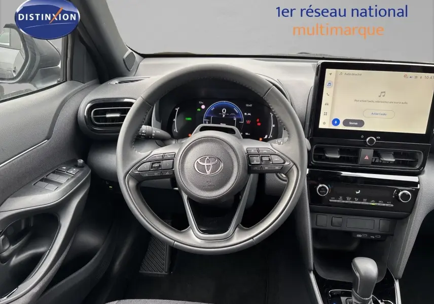 Vue intérieure centrée sur le volant et tableau de bord de la Toyota Yaris Cross hybride, avec écran tactile et finition noire.