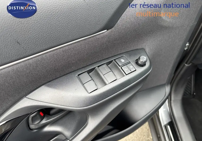 Détail de la porte avant gauche de la Toyota Yaris Cross gris atlas métal, avec commandes des vitres et rétroviseurs.