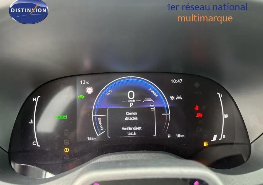 Tableau de bord numérique de Toyota Yaris Cross hybride, affichant la vitesse à 0 km/h et alertes actives, vue frontale.