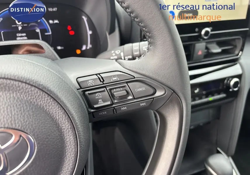 Gros plan sur le volant multifonction et la console centrale de la Toyota Yaris Cross gris atlas, intérieur noir.