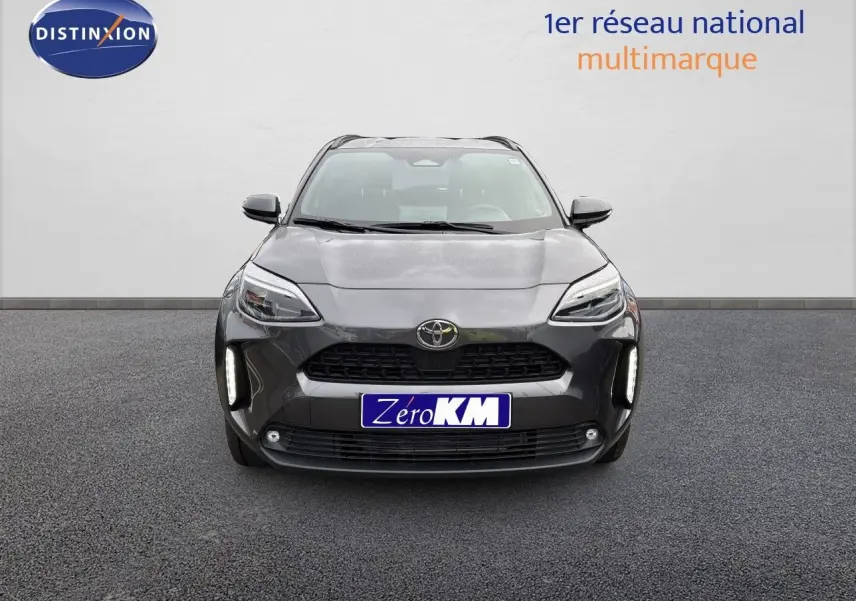 Vue frontale d'une Toyota Yaris Cross gris atlas métal avec feux LED et calandre noire distinctive.