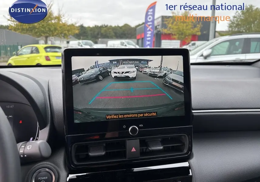 Vue intérieure du tableau de bord de la Toyota Yaris Cross gris atlas, avec écran central affichant la caméra de recul.