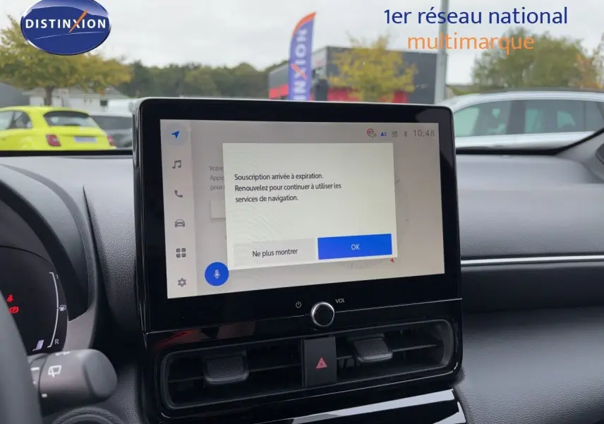 Vue avant intérieure centrée sur l'écran tactile du tableau de bord d'une Toyota Yaris Cross gris atlas metal.