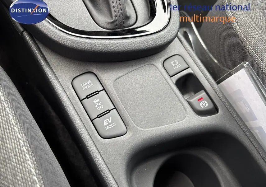 Gros plan sur la console centrale de la Toyota Yaris Cross gris atlas, montrant les boutons Drive Mode, EV Mode et frein à main électrique.
