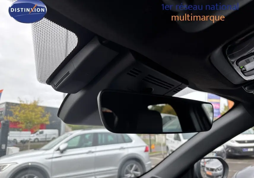 Vue intérieure du rétroviseur central d'une Toyota Yaris Cross gris atlas metal, avec aperçu du pare-brise et extérieur flou.