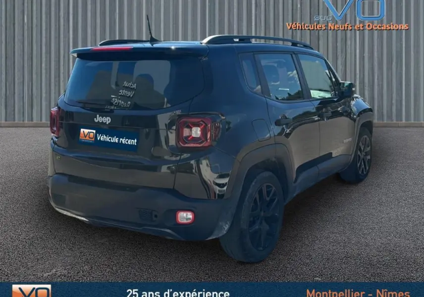 Jeep Renegade noir vue 3/4 arrière droit avec barres de toit et jantes alliage 18 pouces sur sol goudronné