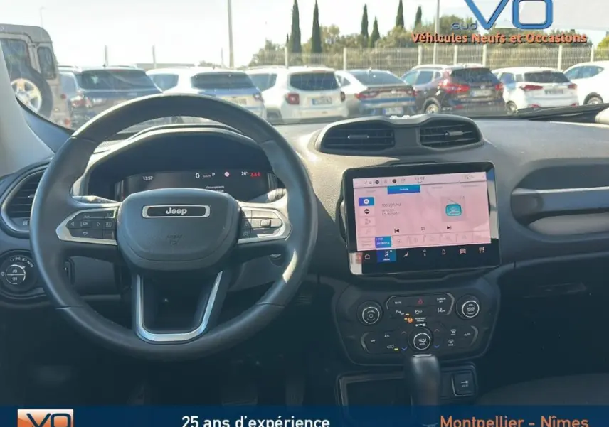 Intérieur du Jeep Renegade 2024, vue frontale sur le volant et l'écran tactile central lumineux.