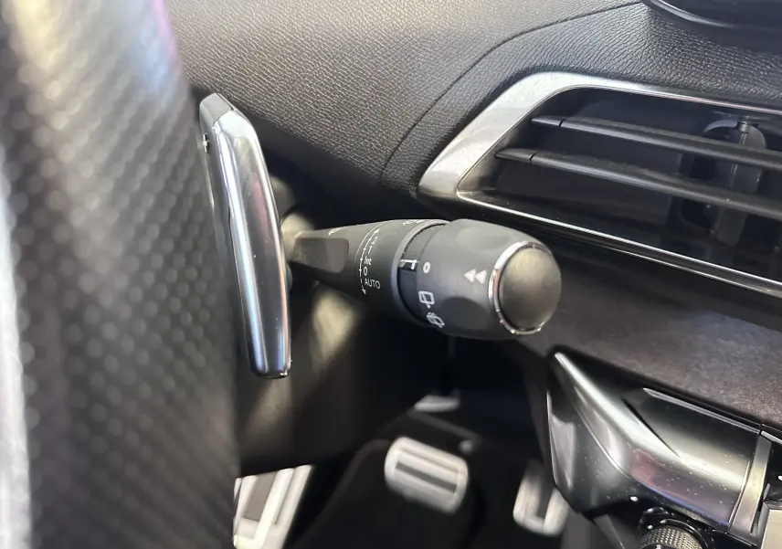 Gros plan sur la commande d'essuie-glace côté droit du tableau de bord noir du Peugeot 3008 blanc nacré 2022.