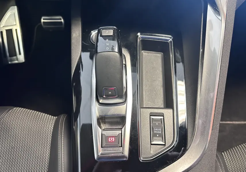 Gros plan sur la console centrale du Peugeot 3008 2022, montrant le levier de vitesses automatique et le bouton Drive Mode.