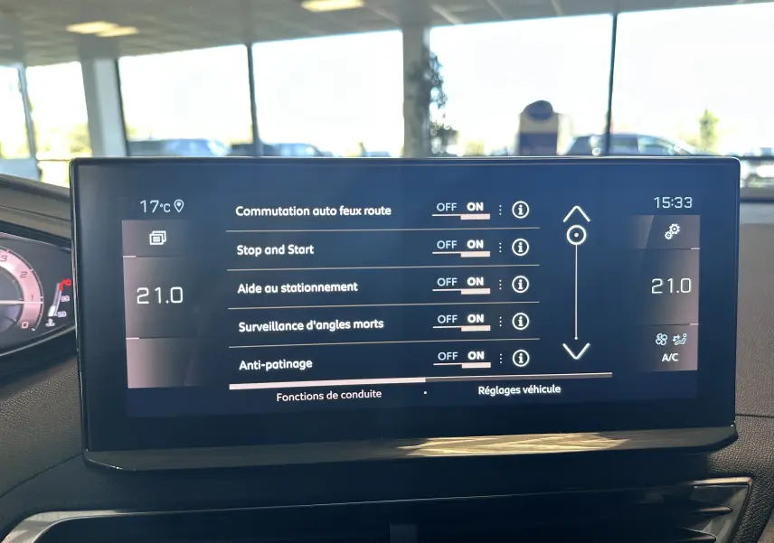 Écran tactile central du Peugeot 3008 blanc nacré, affichant les réglages d’aides à la conduite et climatisation.