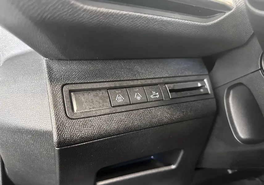 Gros plan sur les boutons de commande côté gauche du tableau de bord noir du Peugeot 3008 blanc nacré 2022.