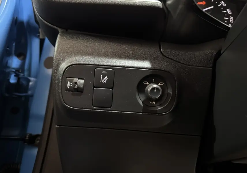 Détail des commandes côté gauche du tableau de bord d’une Citroën C3 bleu 2018, avec réglage des phares et rétroviseurs.