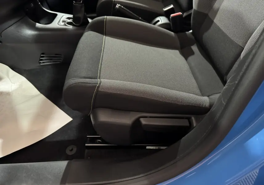 Vue rapprochée du siège avant droit gris et noir de la Citroën C3 bleu, avec levier de vitesse manuel visible.