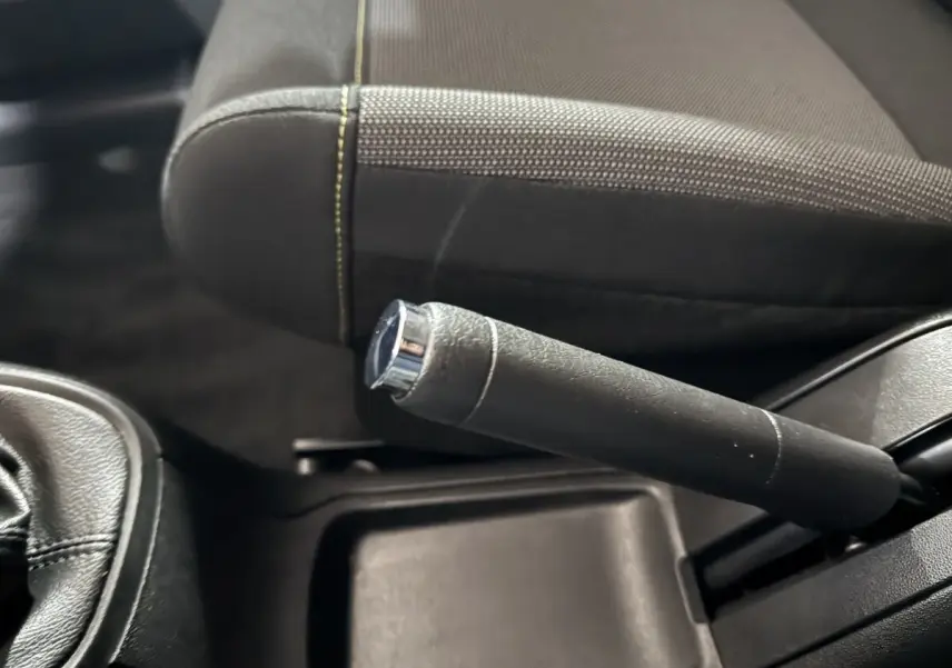 Gros plan sur le frein à main en cuir noir et la partie du siège avant gris foncé de la Citroën C3.