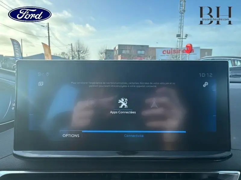 Écran tactile central du tableau de bord d’un Peugeot 5008 blanc Banquise, vue intérieure frontale.