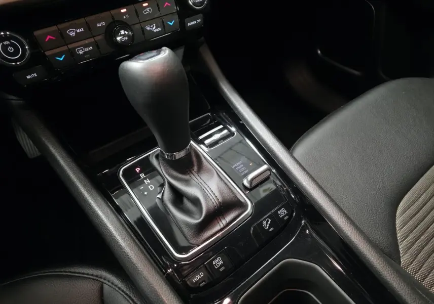 Gros plan sur la console centrale noire avec levier de vitesse et commandes 4WD du Jeep Compass blanc 2024.