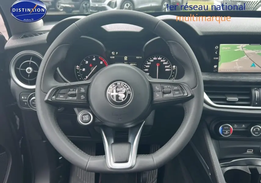 Vue frontale du volant cuir multifonction d'Alfa Romeo Stelvio 2.2 diesel 2021 avec tableau de bord et écran GPS.