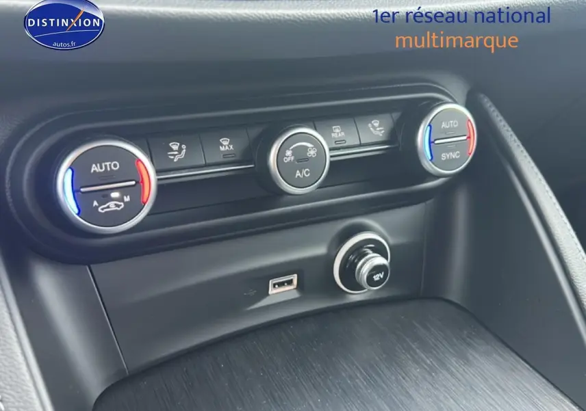 Détail de la console centrale de l'Alfa Romeo Stelvio 2021, montrant les commandes de climatisation et prise 12V.