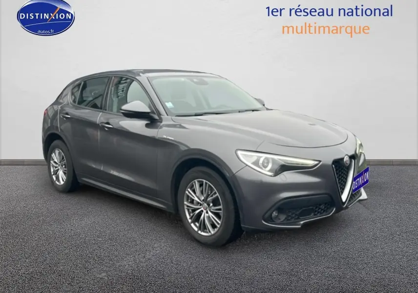 Alfa Romeo Stelvio gris Vesuvio métal en 3/4 avant droit, avec calandre caractéristique et jantes alu multibranches.