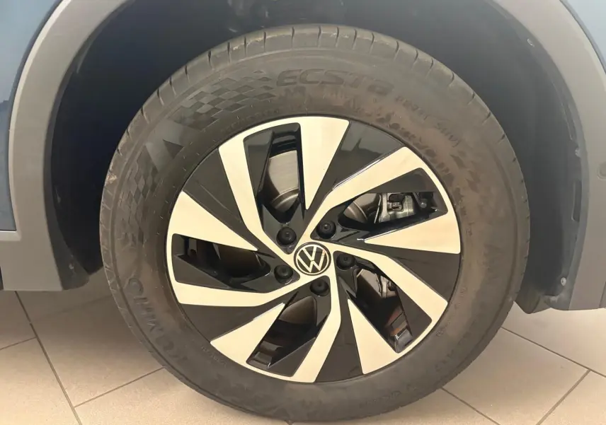 Gros plan sur la roue avant droite du Volkswagen Tiguan 2025 Nightshade Blue, jante alliage bicolore distinctive.