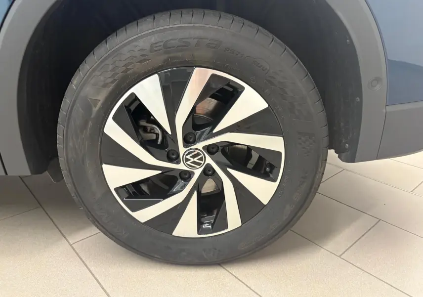 Gros plan sur la roue avant droite du Volkswagen Tiguan 2025 Nightshade Blue avec jante alliage bicolore distinctive.