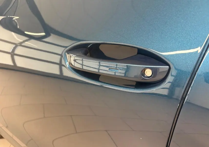 Poignée de porte côté gauche du Volkswagen Tiguan 1.5 eHybrid en peinture métallisée Nightshade Blue.