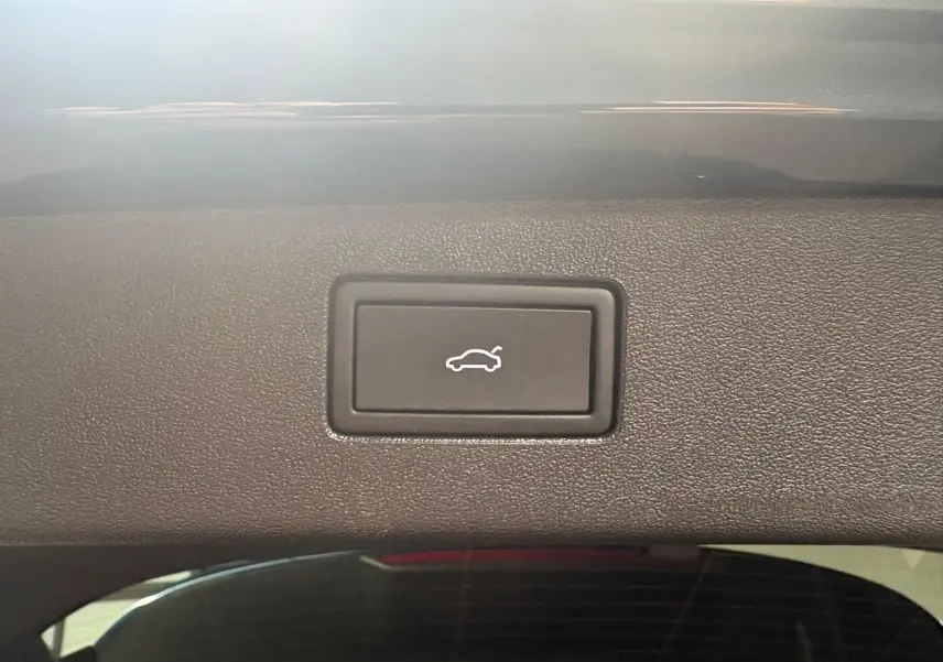 Bouton d'ouverture électrique du coffre sur le hayon intérieur d'un Volkswagen Tiguan 2025 Nightshade Blue.