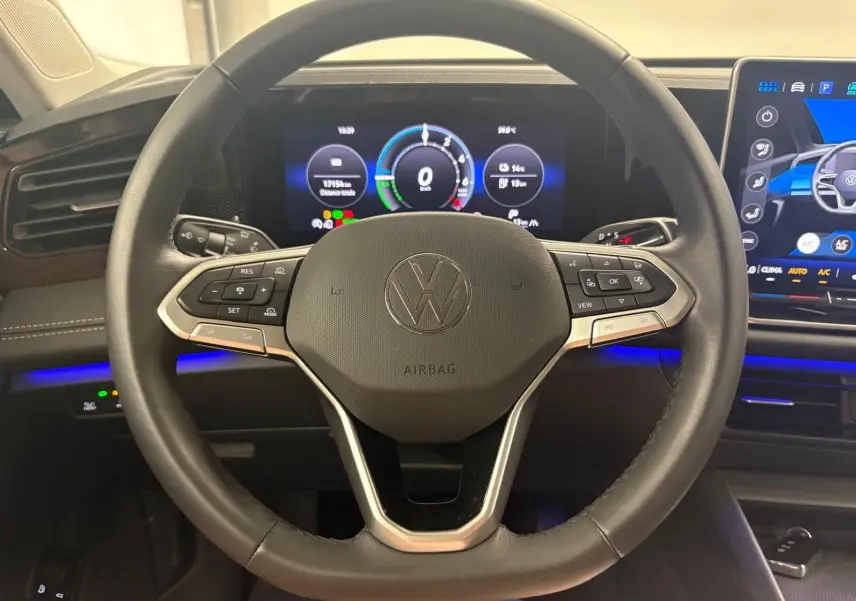Vue rapprochée du volant noir chauffant du Volkswagen Tiguan 1.5 eHybrid 2025 avec tableau de bord numérique et écran tactile.