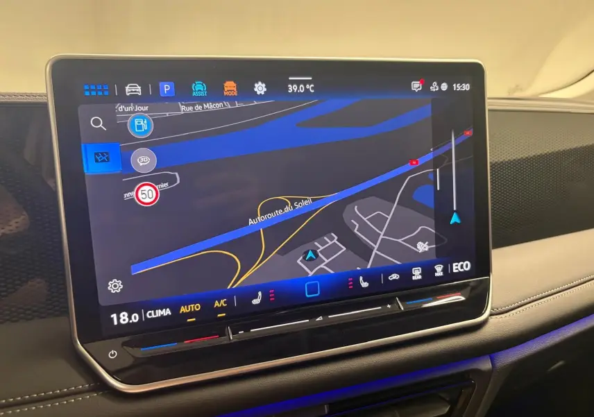 Écran tactile central du Volkswagen Tiguan 2025 affichant la navigation, avec éclairage d'ambiance bleu et tableau de bord beige.