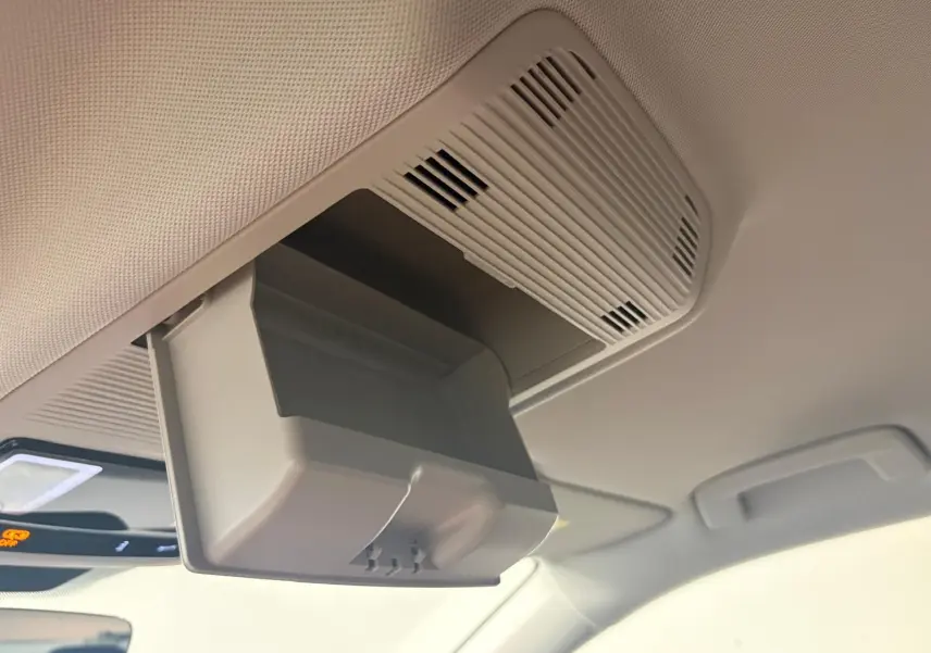 Détail du rangement lunettes ouvert sur le plafond intérieur d’un Volkswagen Tiguan 2025, finition claire.