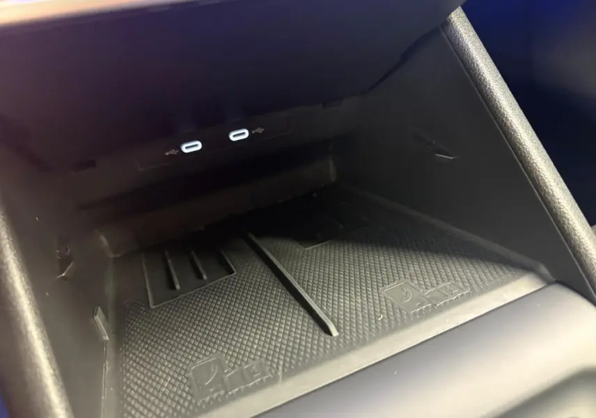 Gros plan sur le compartiment de recharge sans fil avec ports USB du Volkswagen Tiguan 1.5 eHybrid Nightshade Blue.