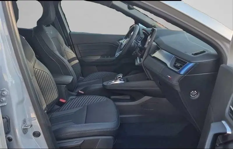 Vue intérieure côté gauche du Renault Captur E-Tech gris Rafale, mettant en valeur les sièges et le tableau de bord moderne.
