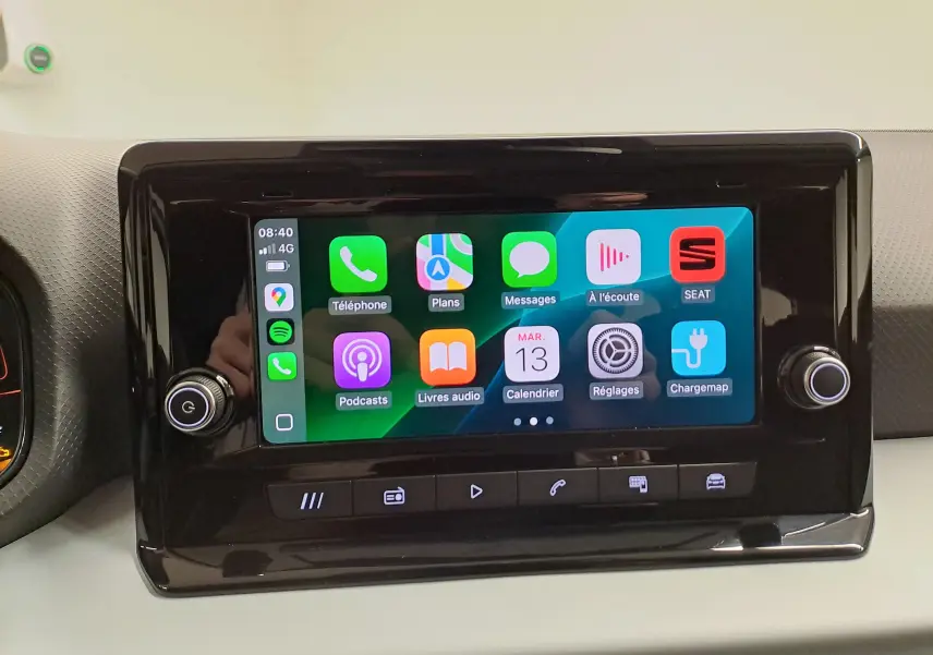 Écran tactile central de la SEAT Ibiza 2024 affichant Apple CarPlay avec interface colorée et boutons de contrôle noirs.