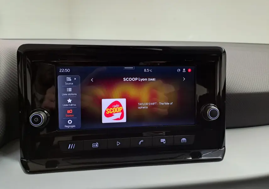 Écran tactile central de la SEAT Ibiza 2024 affichant la radio SCOOP Lyon, avec commandes autour et finition intérieure grise.