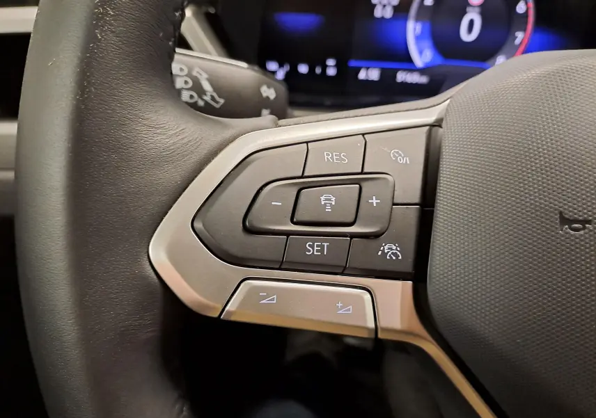 Gros plan sur les commandes au volant du Volkswagen Touran 2025, mettant en valeur les boutons de régulateur de vitesse.