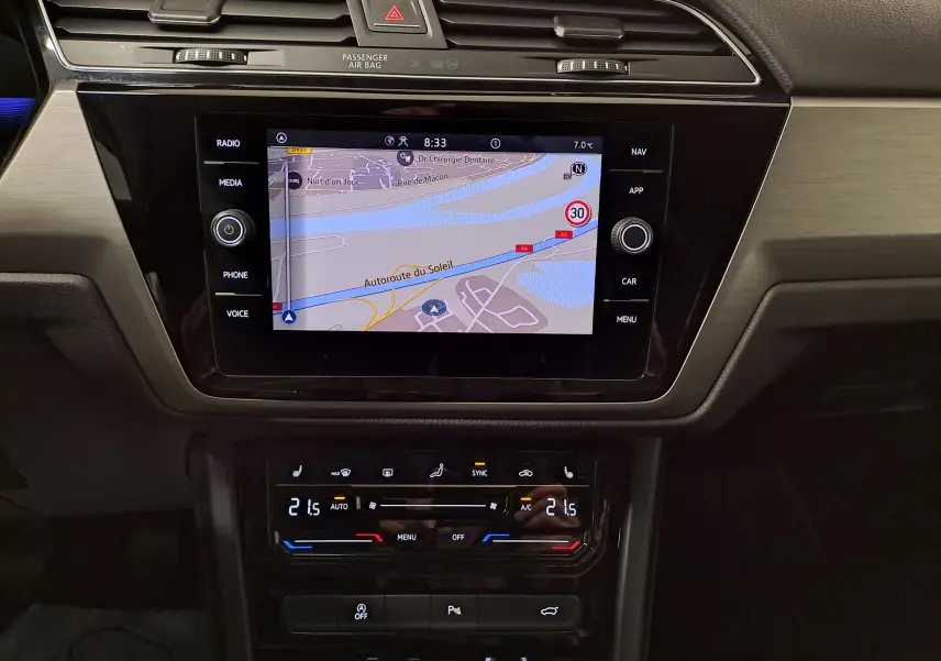 Écran tactile central avec navigation active et commandes climatisation du Volkswagen Touran 2025, intérieur noir.