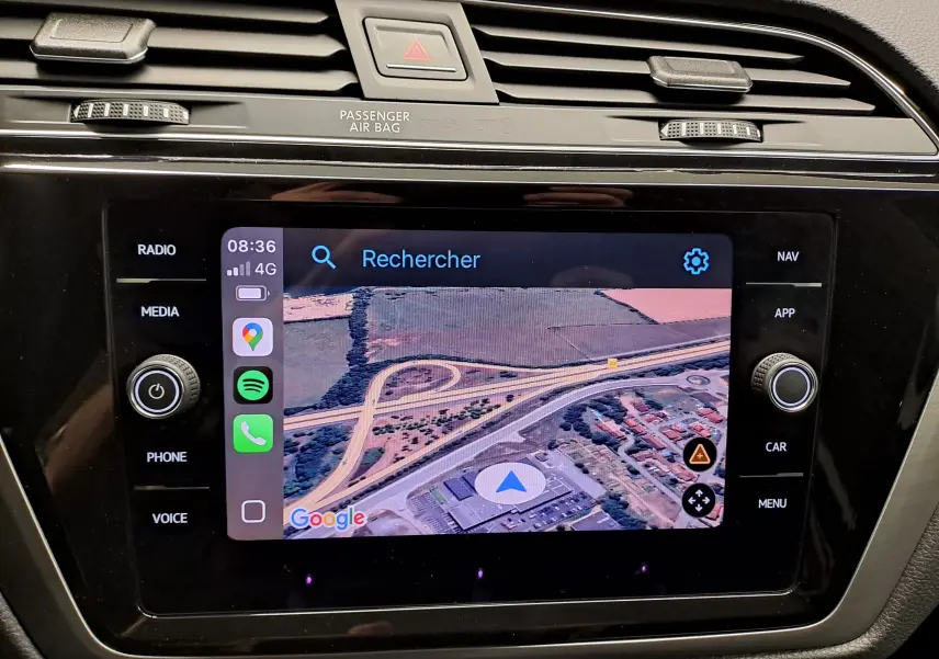 Écran tactile central du Volkswagen Touran 2025 affichant la navigation GPS avec interface connectée, entouré de commandes.
