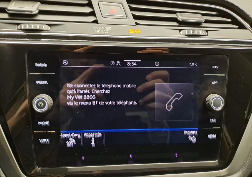 Écran tactile central du Volkswagen Touran 2025 affichant les options de connexion téléphone, entouré de commandes noires.