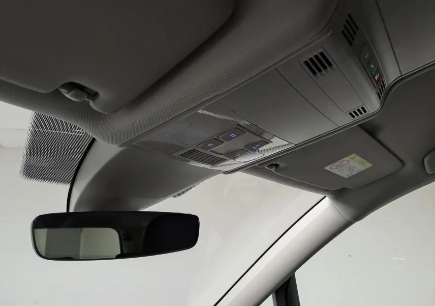Vue intérieure du plafond avant du Volkswagen Touran 2025, montrant le rétroviseur et les commandes d'éclairage intégrées au plafonnier.